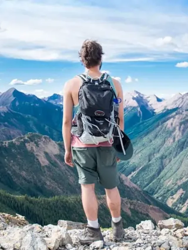 A person standing on the cliff of mountain.