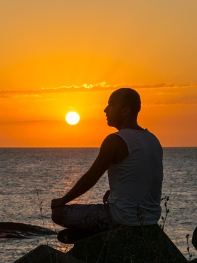 A person meditating near seashore.